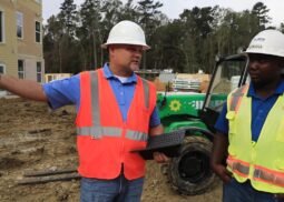 RiskWise safety consultant conducting a job site inspection, discussing safety protocols with a construction worker.