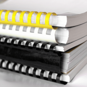 Stack of comb-bound safety manuals representing customized OSHA-compliant written safety programs by RiskWise