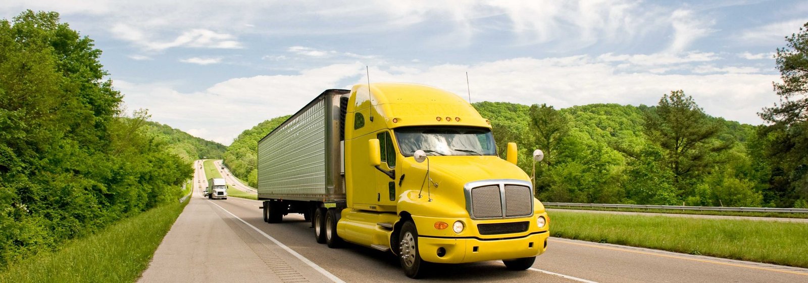 Yellow Semi Truck Travels On Interstate In Springtime Fleet safety